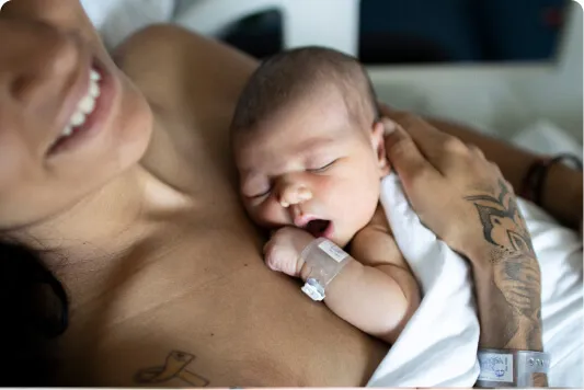 Newborn baby sleeping against a parent’s chest
